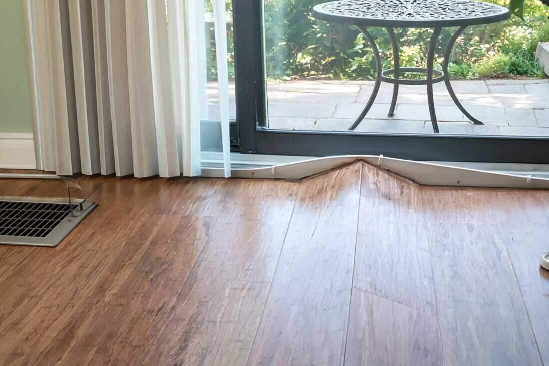 A cupped, water-damaged hardwood floor in a Brooklyn home