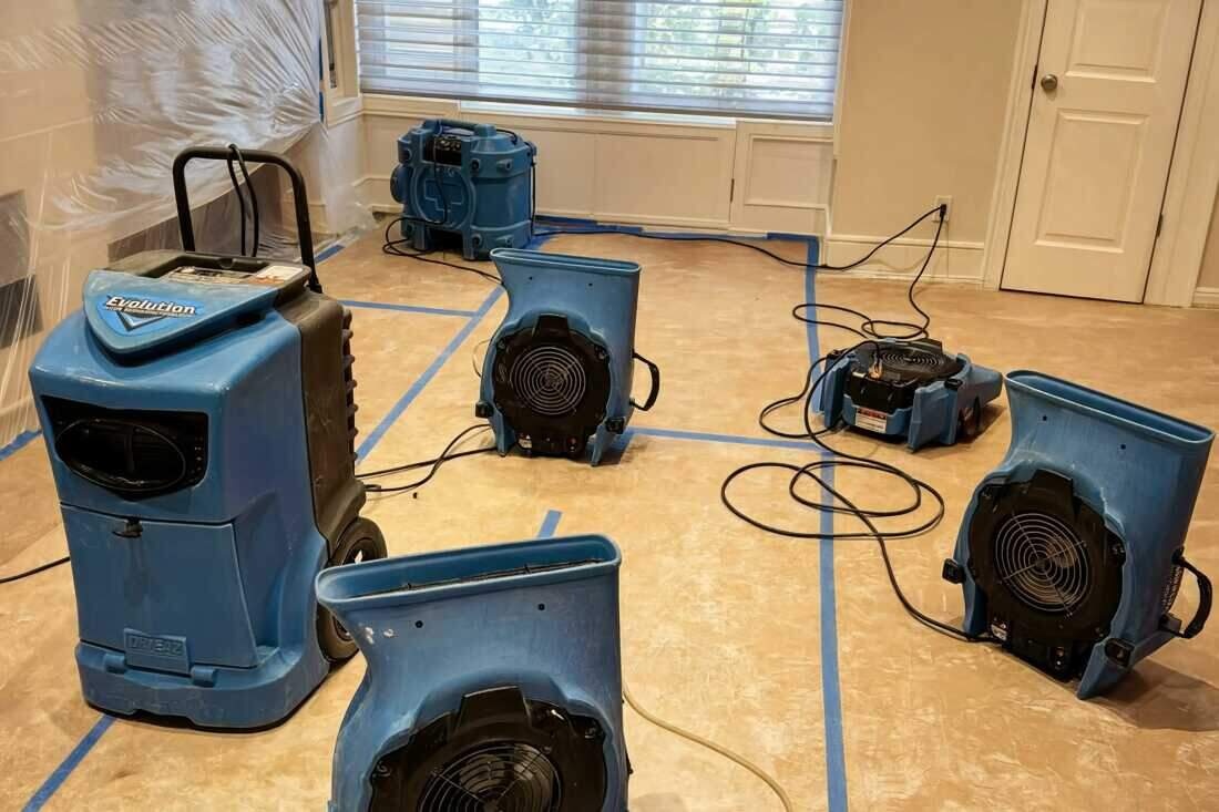 Air movers and a dehumidifier drying a water-damaged Brooklyn room